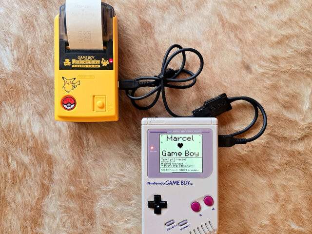 A Game Boy Printer printing a custom LABEL BOY label reading 'Marcel LOVES Game Boy'