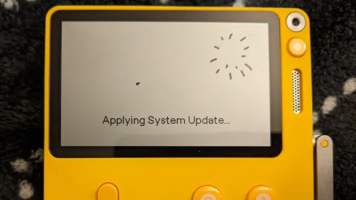 A yellow Playdate handheld displaying the Questy Chess game on its screen