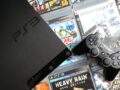PS3 Slim console with DualShock 3 controller and stacked PS3 game cases