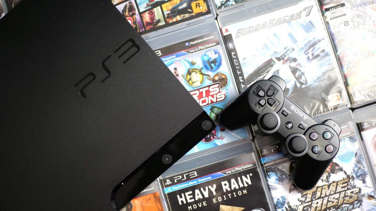 PS3 Slim console with DualShock 3 controller and stacked PS3 game cases
