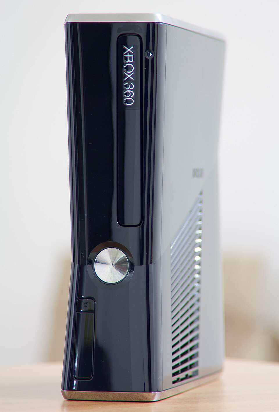 A black Xbox 360 S console standing vertically